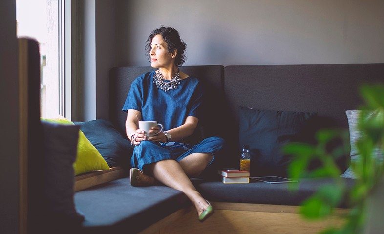 一个女人坐在沙发上看着窗外