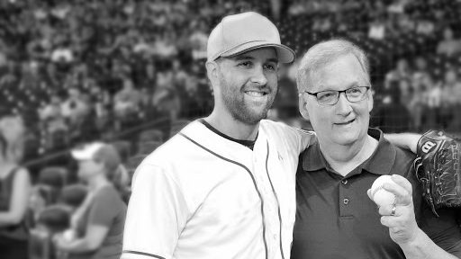 Collin MChugh在他爸爸周围裹着他的手臂 - 一个前列腺癌幸存者 - 在棒球比赛中